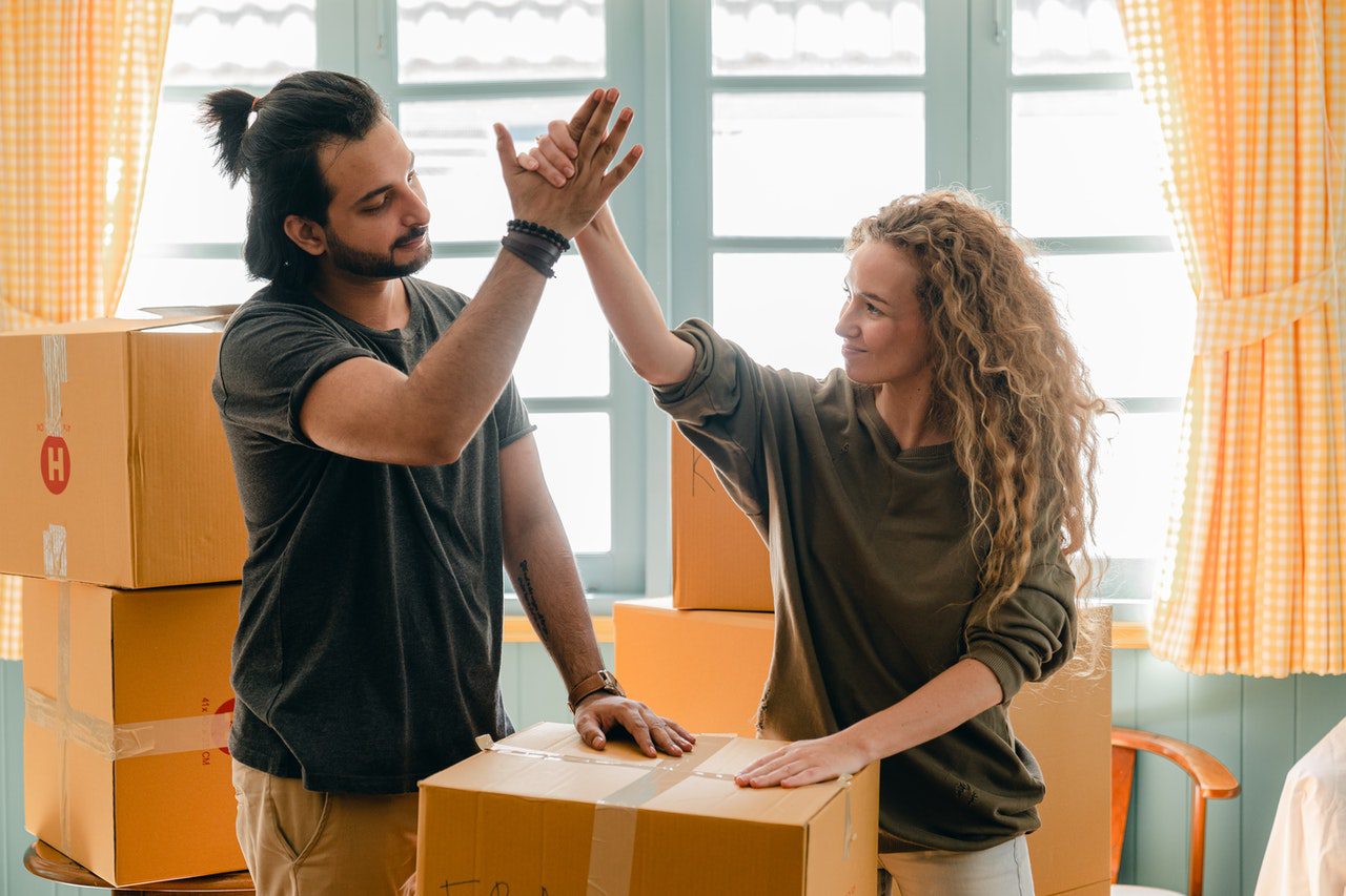 A couple high-fiving after successfully packing for relocation